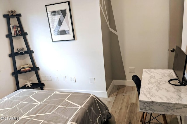 bedroom featuring baseboards and wood finished floors