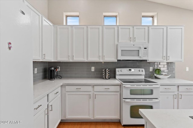 kitchen featuring white cabinetry, a healthy amount of sunlight, tasteful backsplash, and white appliances