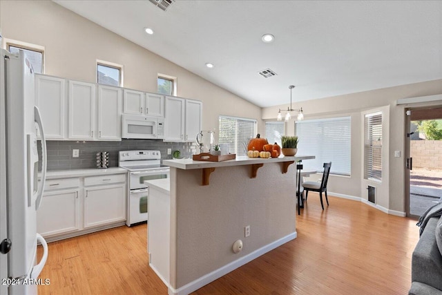 kitchen with light hardwood / wood-style flooring, white cabinetry, decorative light fixtures, and white appliances