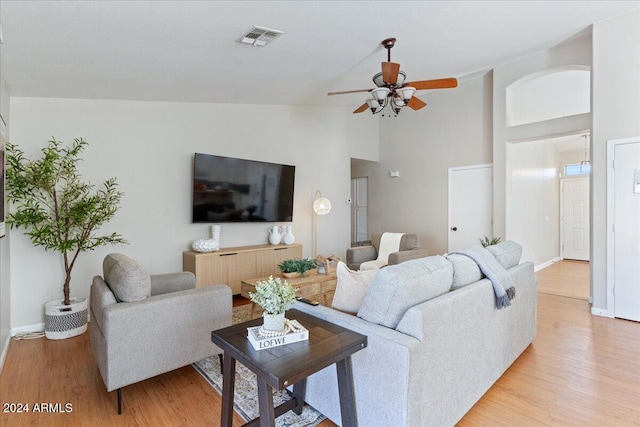 living room featuring light hardwood / wood-style floors, high vaulted ceiling, and ceiling fan