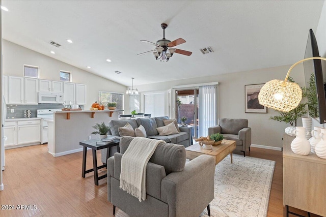 living room featuring light hardwood / wood-style floors, lofted ceiling, and ceiling fan with notable chandelier