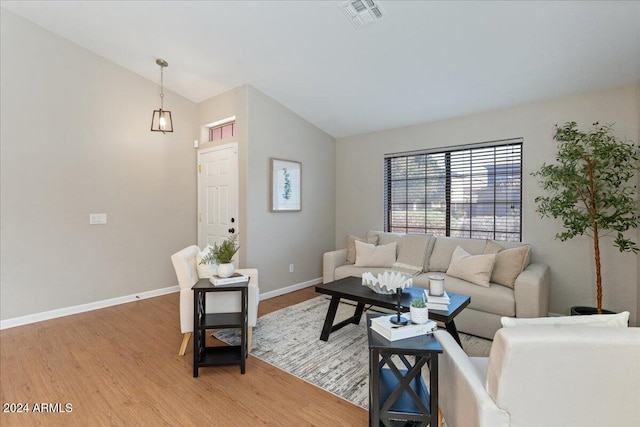 living room featuring lofted ceiling and hardwood / wood-style floors