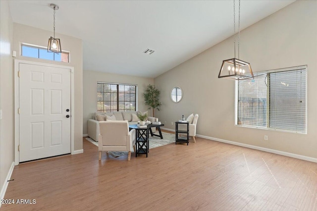 entryway featuring hardwood / wood-style floors, a chandelier, and high vaulted ceiling