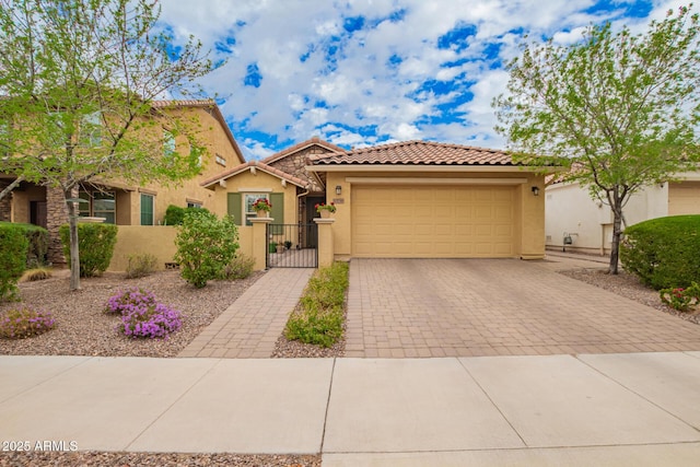 view of front of home featuring a fenced front yard, decorative driveway, an attached garage, and stucco siding