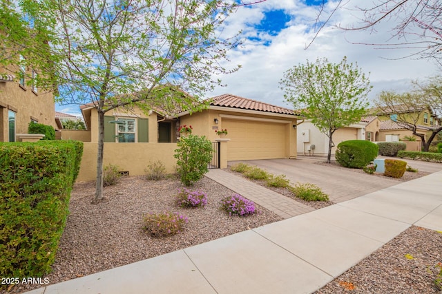 view of front facade featuring fence, stucco siding, a garage, a tile roof, and decorative driveway