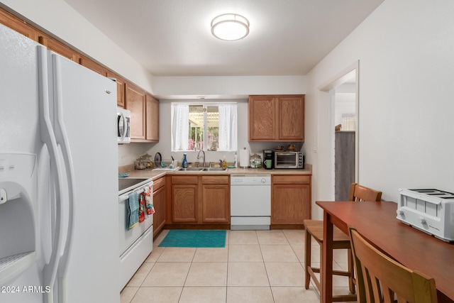 kitchen with light tile patterned flooring, white appliances, and sink