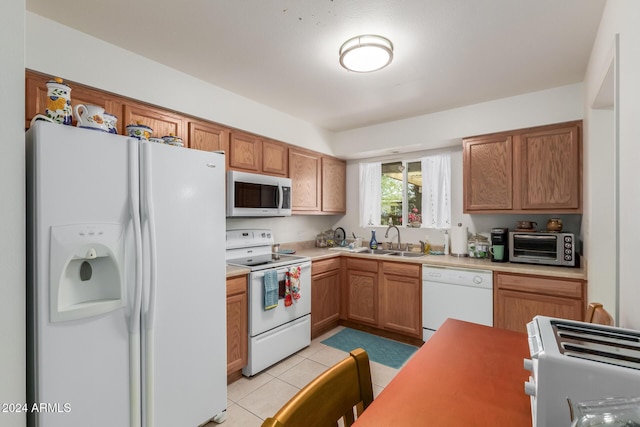 kitchen with sink, light tile patterned floors, and white appliances