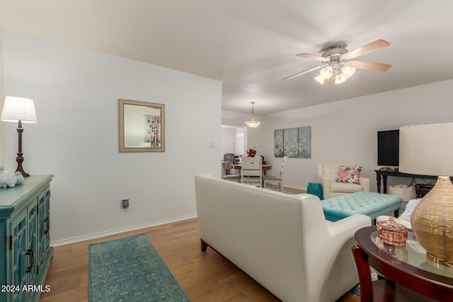 living room featuring ceiling fan and light hardwood / wood-style floors