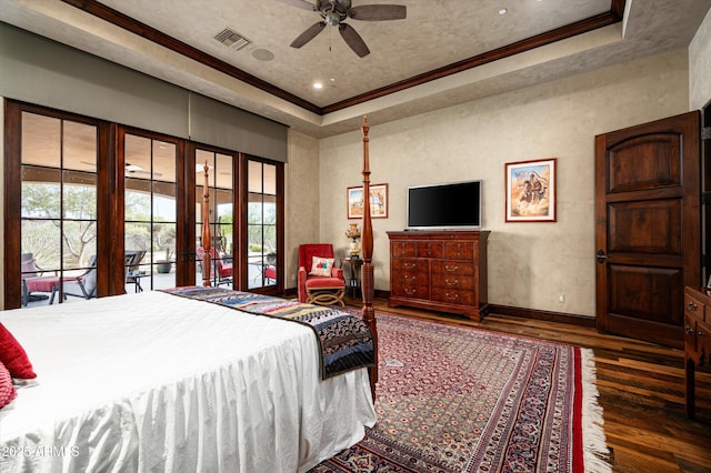 bedroom with a raised ceiling, wood finished floors, multiple windows, french doors, and crown molding