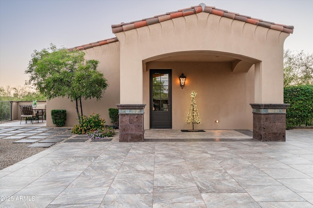 doorway to property featuring a patio and stucco siding