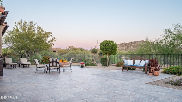 patio terrace at dusk featuring fence
