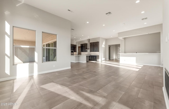 unfurnished living room with baseboards, visible vents, and recessed lighting