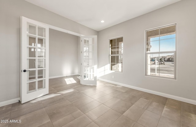 tiled spare room featuring recessed lighting, baseboards, and french doors