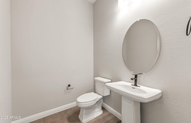 half bath featuring toilet and baseboards