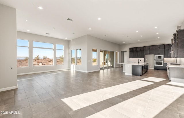 unfurnished living room featuring recessed lighting, visible vents, and light tile patterned floors