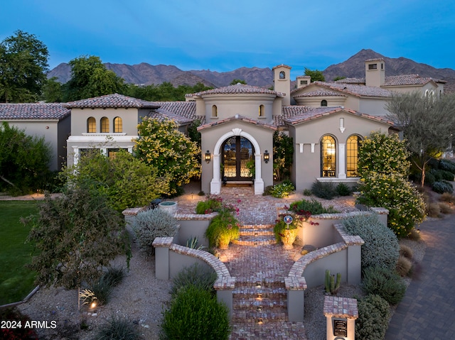 mediterranean / spanish-style home with a mountain view and french doors