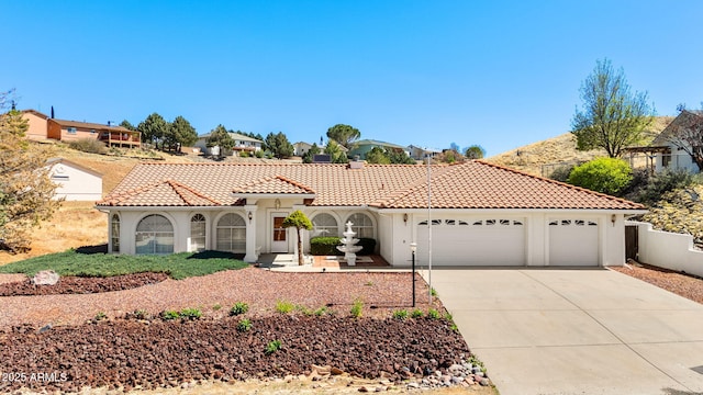 4701 N Sheridan Ln, Prescott Valley, AZ 86314 - mediterranean / spanish-style home with an attached garage, driveway, a tiled roof, and stucco siding
