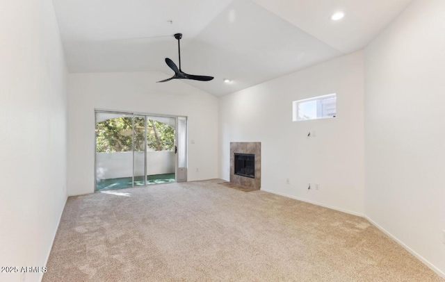 unfurnished living room with lofted ceiling, ceiling fan, a fireplace, and light carpet