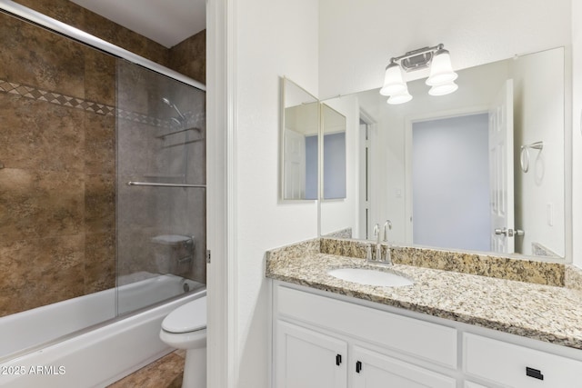 full bathroom featuring combined bath / shower with glass door, vanity, and toilet