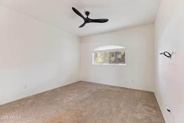 spare room featuring light carpet and ceiling fan