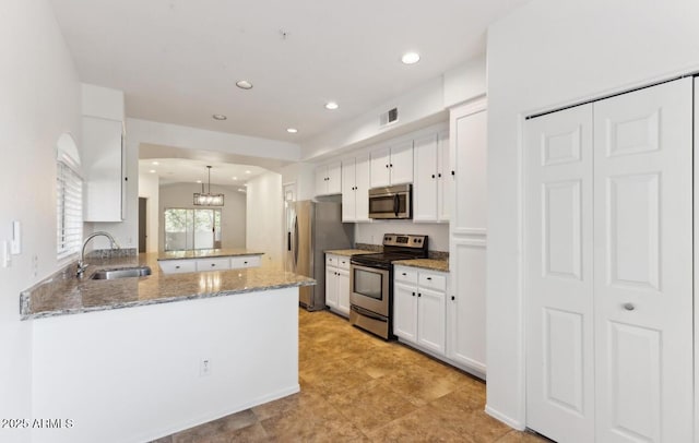 kitchen featuring kitchen peninsula, sink, white cabinetry, hanging light fixtures, and stainless steel appliances