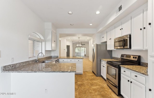 kitchen with white cabinetry, stainless steel appliances, sink, kitchen peninsula, and a notable chandelier