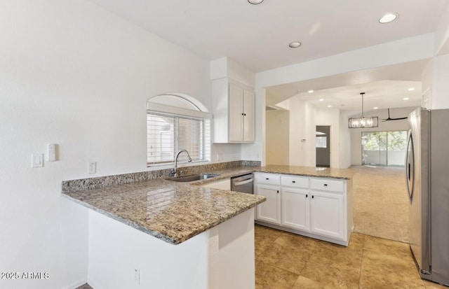 kitchen featuring white cabinetry, stainless steel appliances, kitchen peninsula, and sink