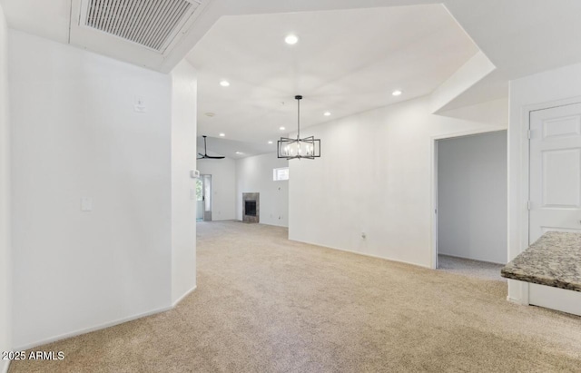 unfurnished living room with light colored carpet and a tiled fireplace