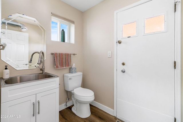 bathroom featuring toilet, vanity, and hardwood / wood-style flooring