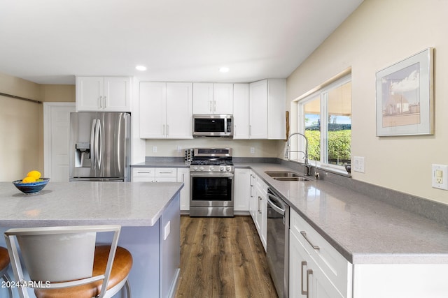 kitchen featuring a kitchen breakfast bar, white cabinetry, stainless steel appliances, and dark hardwood / wood-style floors