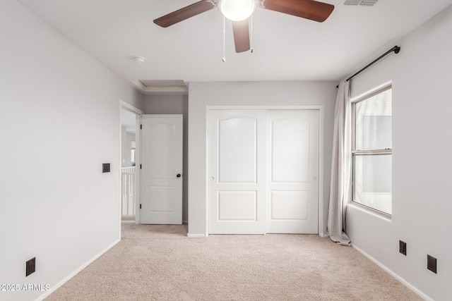 unfurnished bedroom featuring a closet, light colored carpet, visible vents, and baseboards