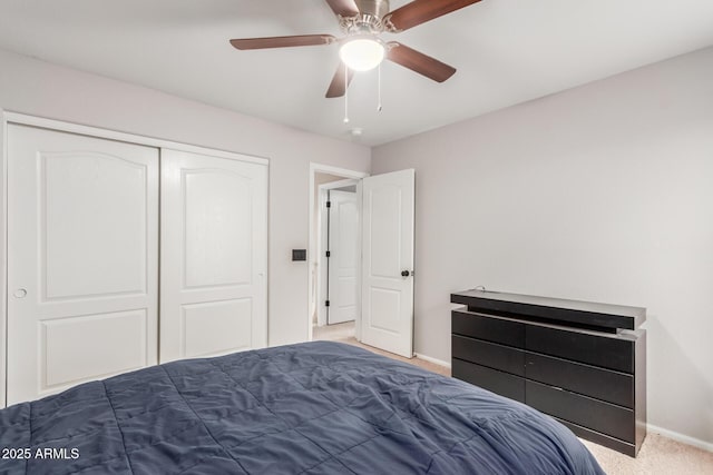 carpeted bedroom featuring a closet, a ceiling fan, and baseboards