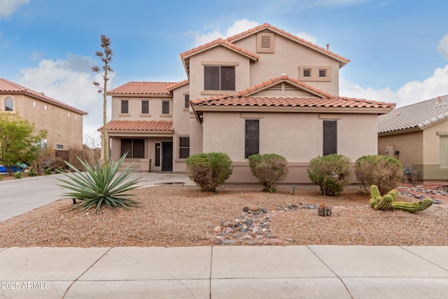 mediterranean / spanish-style home with a tiled roof and stucco siding