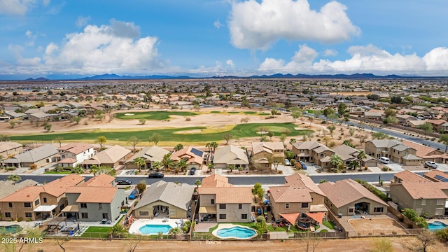 drone / aerial view with a mountain view, golf course view, and a residential view