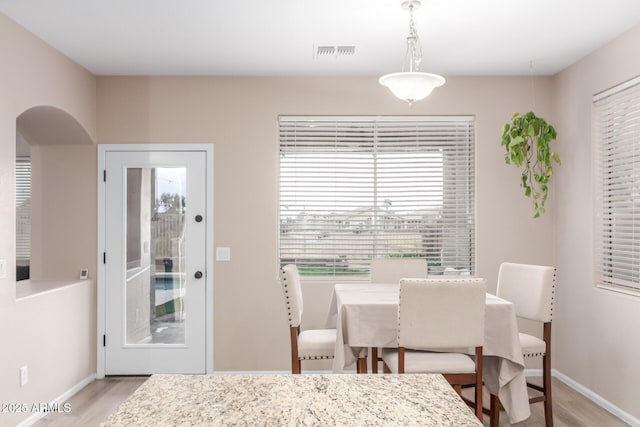 dining space featuring baseboards, visible vents, and light wood-style floors