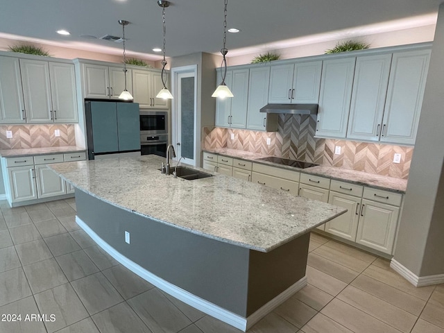 kitchen featuring black electric cooktop, a kitchen island with sink, sink, and oven