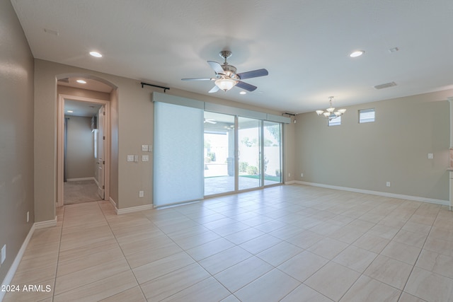 empty room featuring light tile patterned floors and ceiling fan with notable chandelier