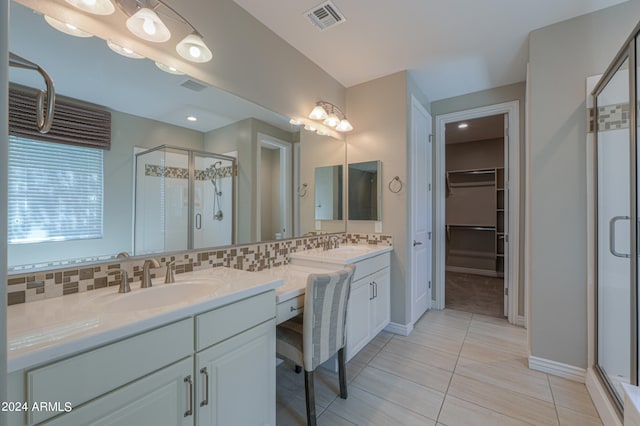 bathroom with tile patterned floors, decorative backsplash, a shower with door, and vanity