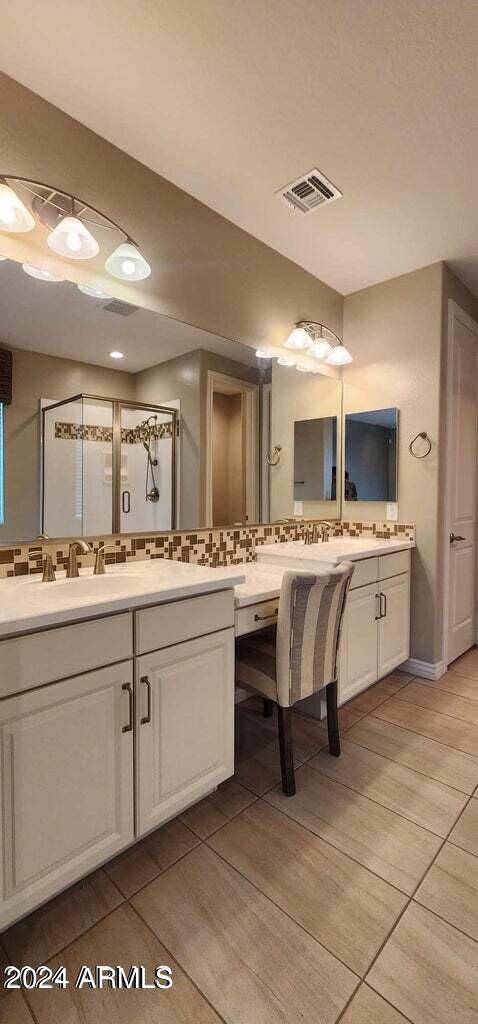 bathroom with vanity, backsplash, tile patterned floors, and walk in shower