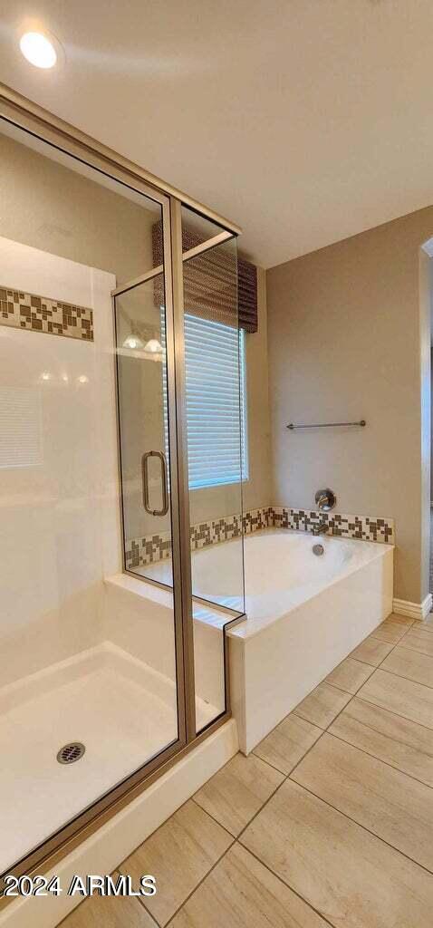 bathroom featuring tile patterned flooring and independent shower and bath