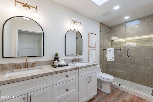 bathroom featuring hardwood / wood-style floors, vanity, toilet, and an enclosed shower