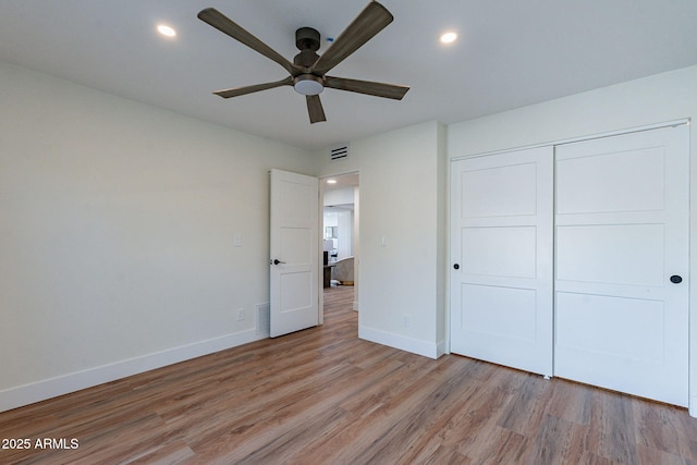 unfurnished bedroom featuring ceiling fan, light hardwood / wood-style floors, and a closet