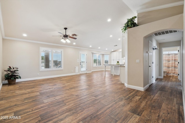 23705 N Chaps Dr, Florence, AZ 85132 - unfurnished living room featuring arched walkways, a ceiling fan, wood finished floors, crown molding, and baseboards