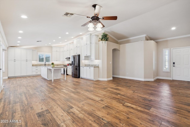 23705 N Chaps Dr, Florence, AZ 85132 - kitchen featuring refrigerator with ice dispenser, crown molding, ceiling fan, a kitchen bar, and light countertops