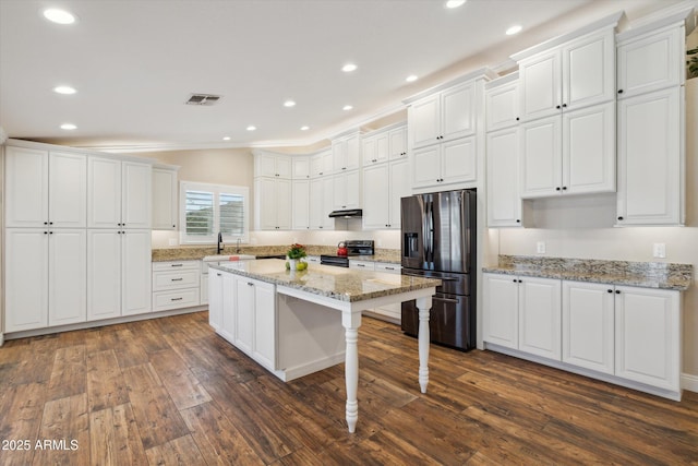 23705 N Chaps Dr, Florence, AZ 85132 - kitchen with appliances with stainless steel finishes, dark wood-type flooring, white cabinetry, under cabinet range hood, and recessed lighting