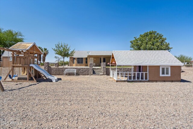 23705 N Chaps Dr, Florence, AZ 85132 - rear view of house with stucco siding and a playground