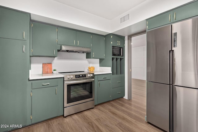 103 E Palm Ln Unit A, Phoenix, AZ 85004 - kitchen with stainless steel appliances, under cabinet range hood, light wood-style floors, and light countertops