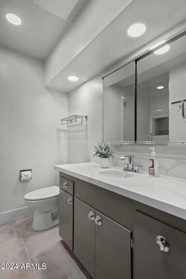 103 E Palm Ln Unit A, Phoenix, AZ 85004 - bathroom featuring toilet, vanity, a stall shower, tile patterned flooring, and baseboards