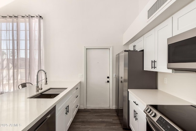 830 E Gila Ln, Chandler, AZ 85225 - kitchen with a sink, stainless steel appliances, dark wood-style floors, white cabinets, and light countertops