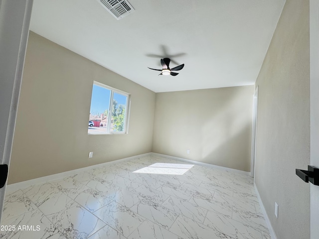 spare room with ceiling fan, marble finish floor, visible vents, and baseboards